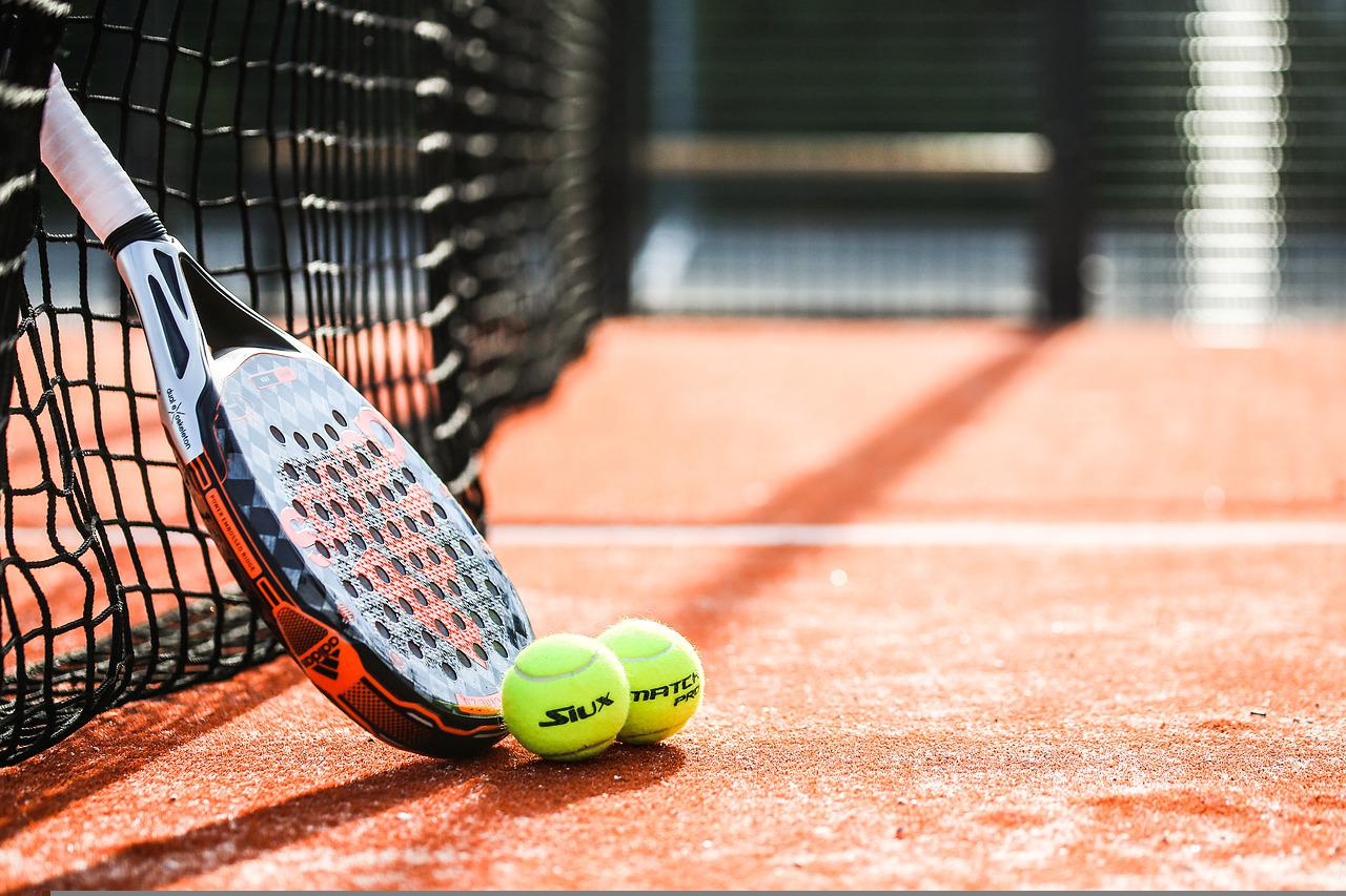 Imagem de uma raquete e duas bolas de tenis